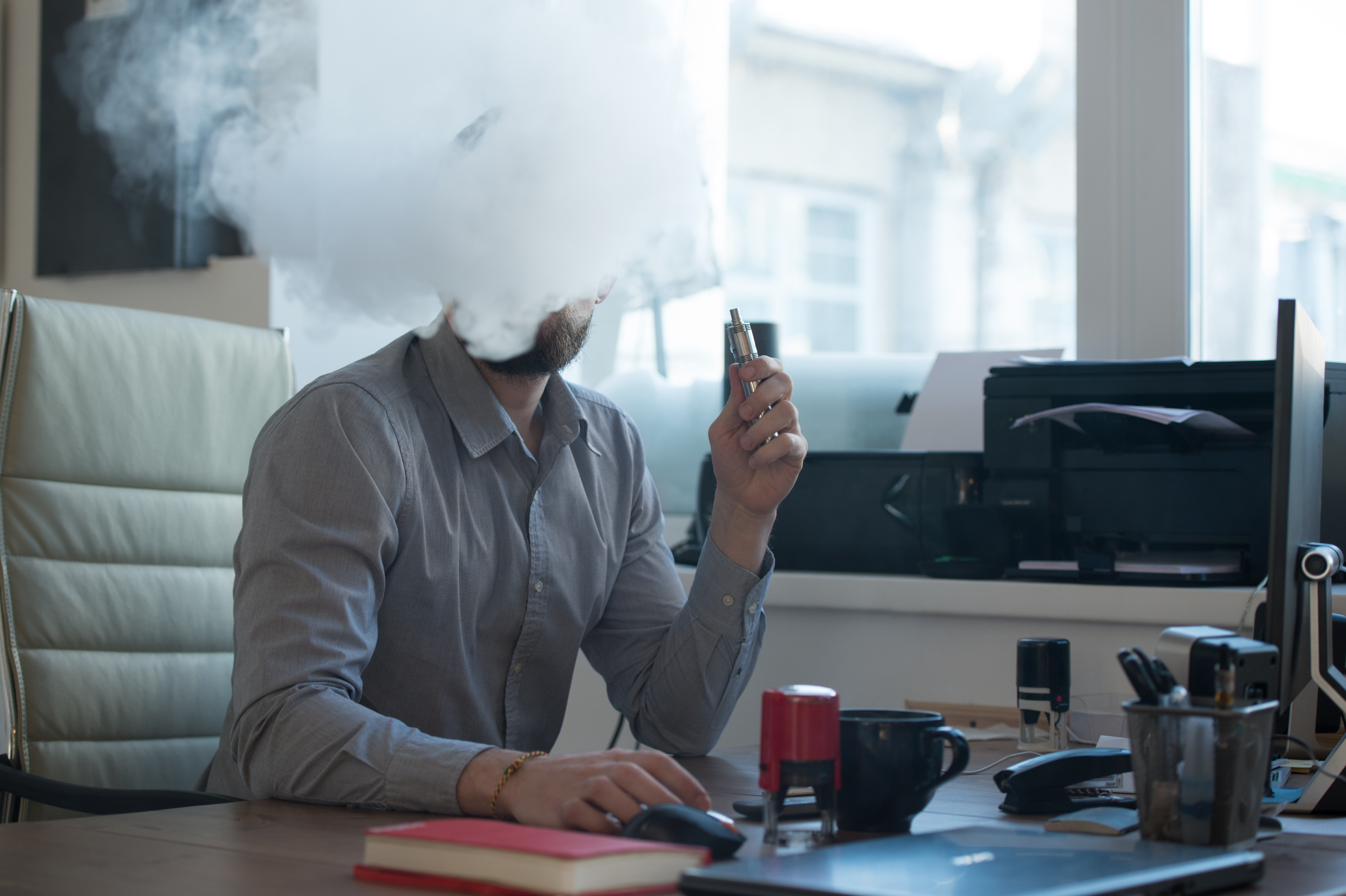 Курение на открытом воздухе. Курение в офисе. Курящий человек в офисе. Человек курит на рабочем месте. Курят у офиса.